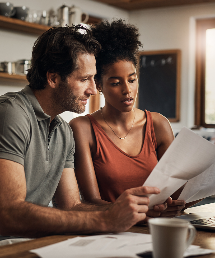 A man and a woman reviewing bank account statements together. 